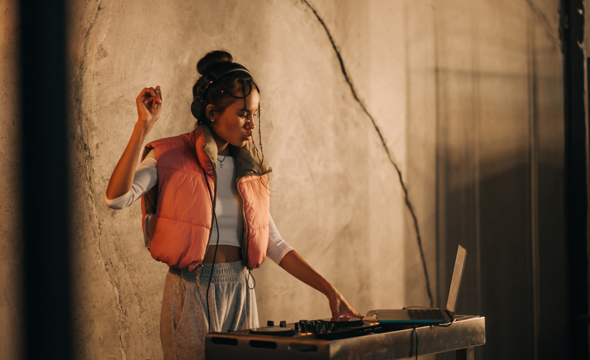 Fulminante Re-Launch-Party lässt Herzen und Seismographen höher schlagen 26 Expressive female DJ in headphones plays music on the remote control and dances on the background of a concrete wall. (c) AdobeStock
