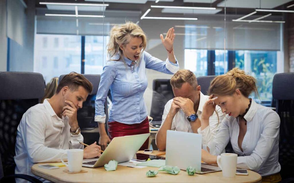 Eine Chefin, die mit ihren Mitarbeiterinnen schreit. (c) AdobeStock