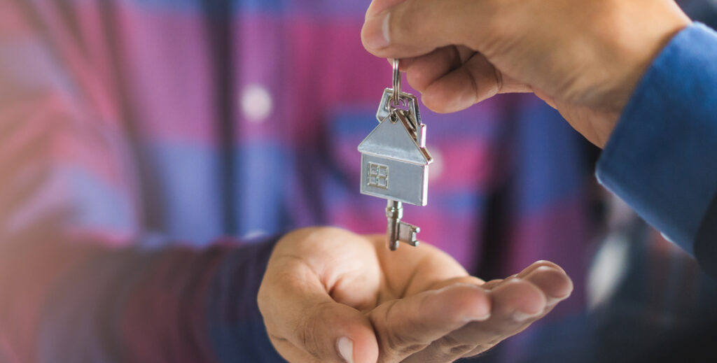 Close up view hand of property realtor / landlord giving key house to buyer / tenant. banner wide side. (c) AdobeStock