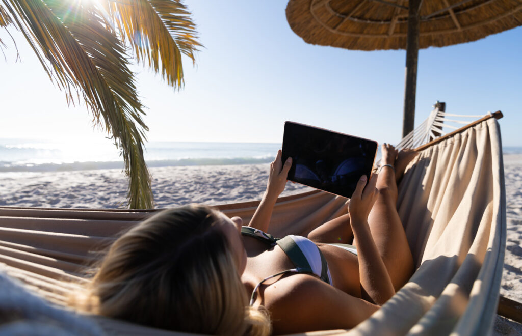 KI an der Börse – in Picosekunden zum Multitrillionär 1 Eine Frau in der Hängematte beim Lesen auf einem iPad, Stichwort KI an der Börse.
(c) AdobeStock