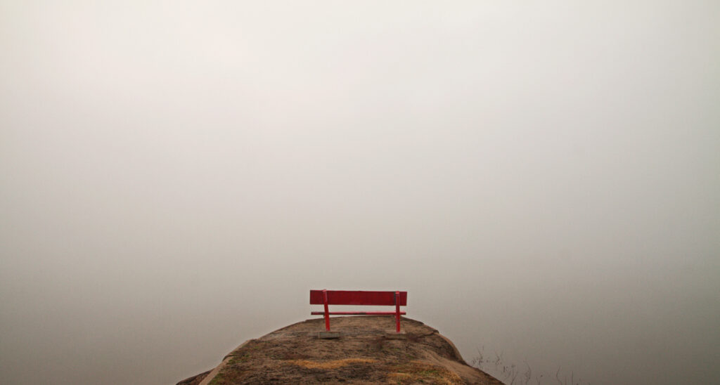 Bench at mountain peak in foggy weather. (c) AdobeStock
