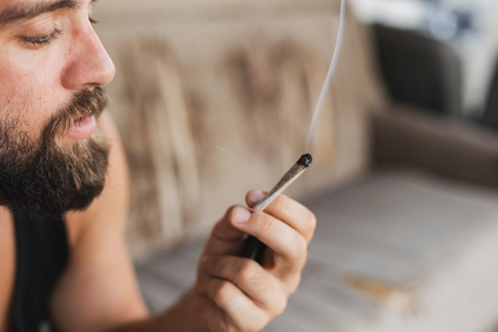 Hanno F.: "Seit dem 500kg-Service funktioniert mein Grinder wieder wie früher!" 1 Young man sitting on a couch, relaxing and smoking pot, keyword grinder.
(c) AdobeStock