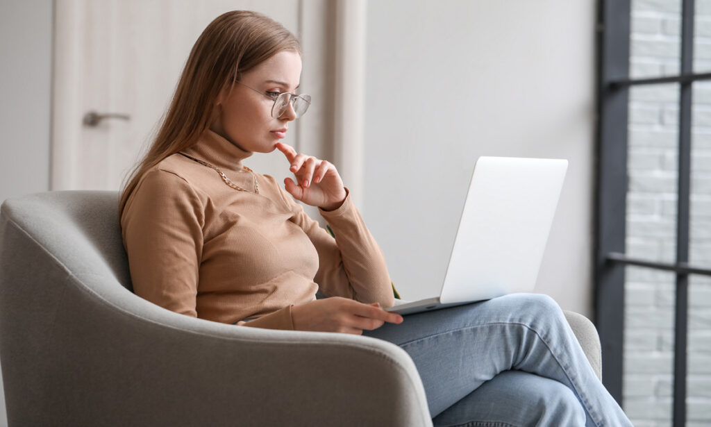 Female psychologist video chatting with patient on laptop at home. (c) AdobeStock