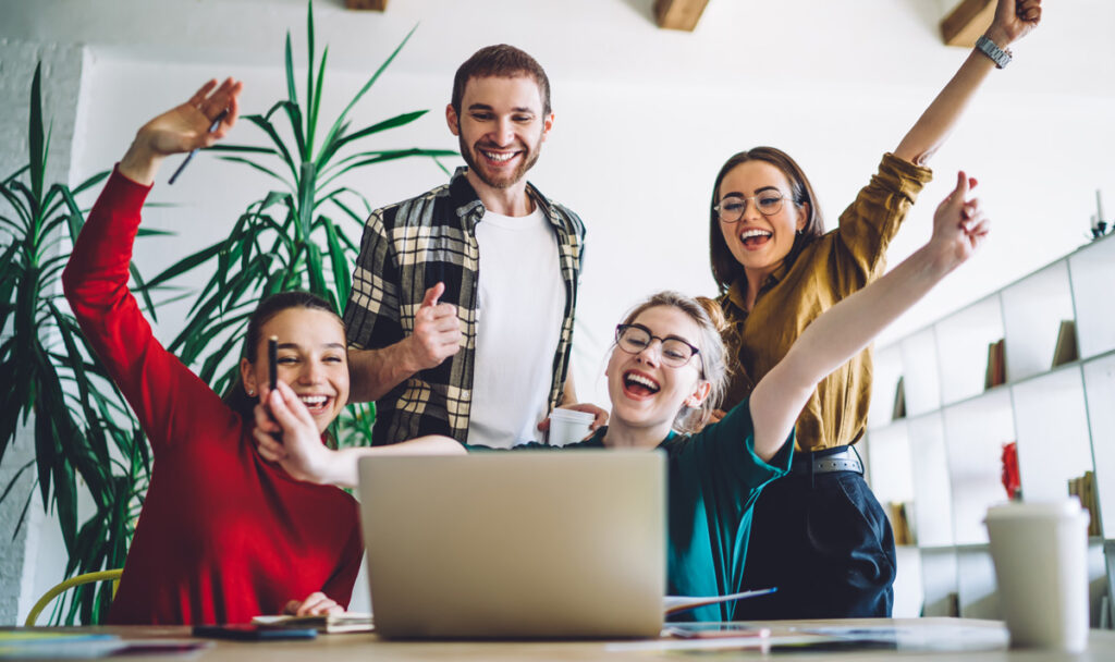 Kaffee und Netflixabo ab 2025/ 26 in Studiengebühren inkludiert! Jubelnde Studenten vor einem Laptop. (c) AdobeStock
