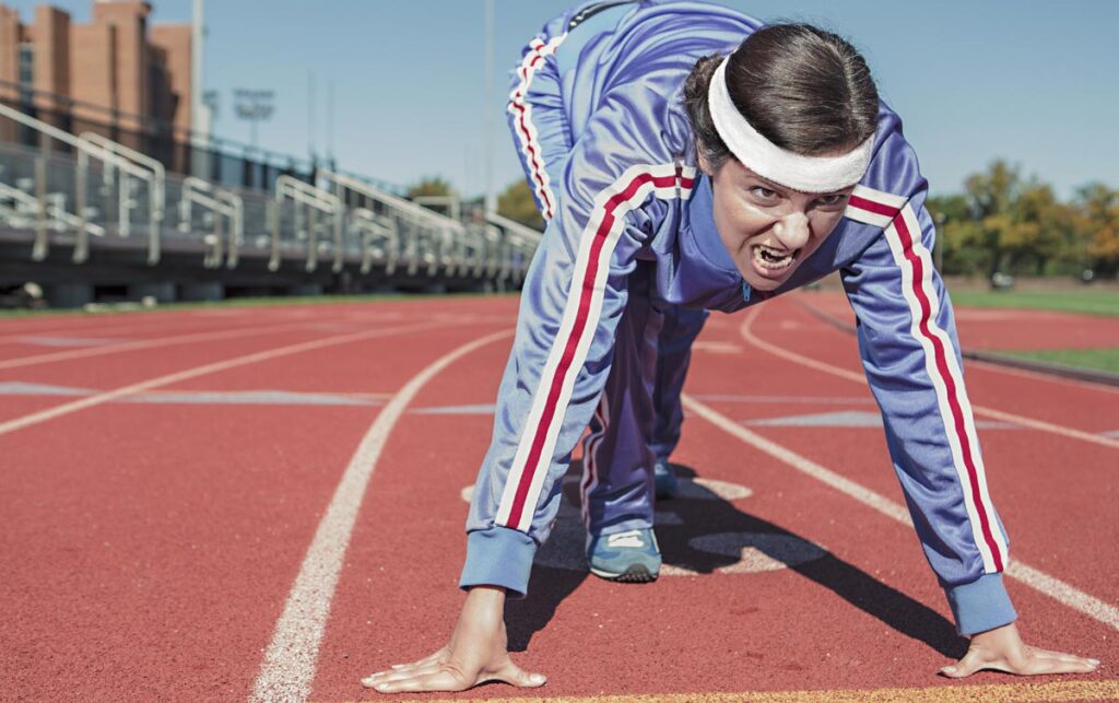 Eine Läuferin beim Start auf einer Laufbahn. (c) Pixabay.com