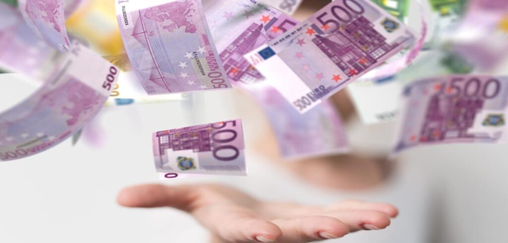 Die Hand eines Mannes, der 500 Euro Scheine auffängt. (c) AdobeStock