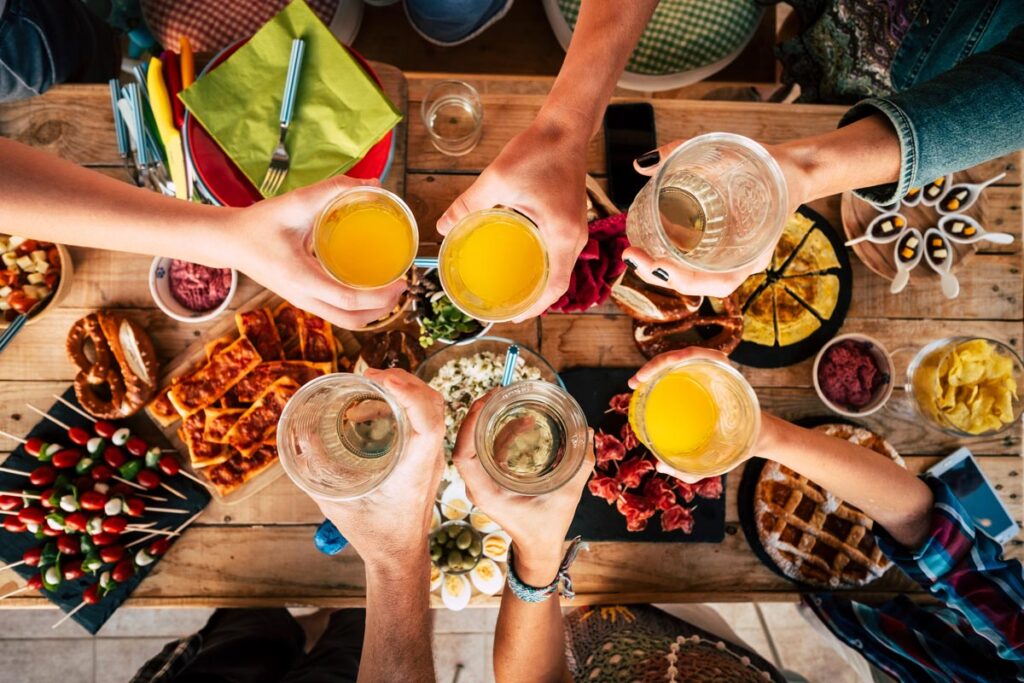 "Finden kein Personal" – erstes »Bring-Your-Own-Food« Restaurant in Tirol eröffnet 1 6 Hände mit Gläsern beim Zusammenprosten auf einem prall gedeckten Tisch, Stichwort Personalmangel.
(c) AdobeStock