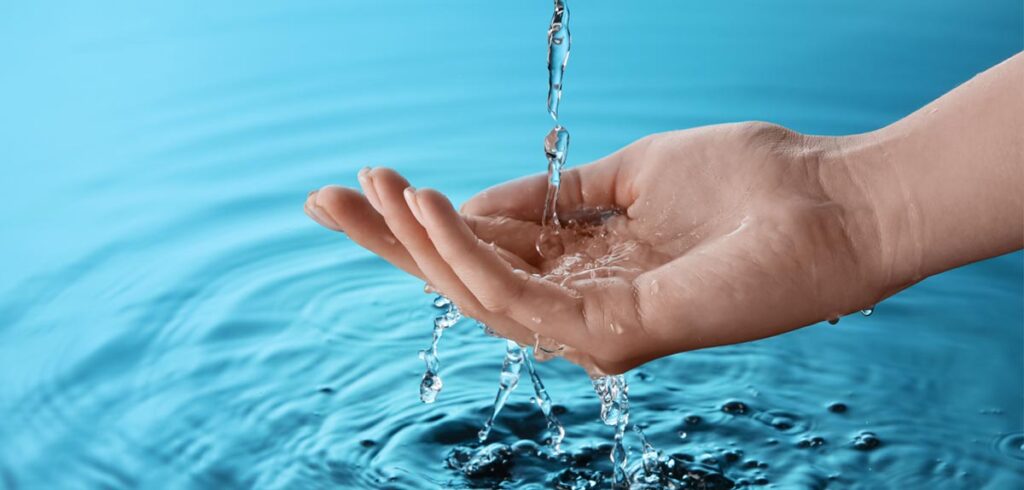 Die Hand einer Frau, in die Wasser rinnt. (c) AdobeStock