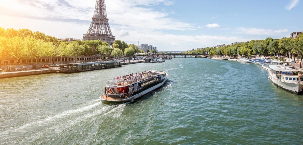 Ein Boot auf der Seine, dahinter der Eifelturm. (c) AdobeStock