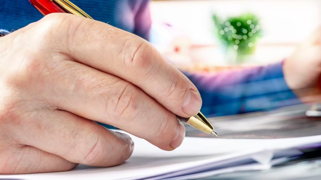 Raiffeisen übernimmt den Bauernbund – Nun auch offiziell! 1 Die Hand eines Mannes, der einen Kugelschreiber hält, Stichwort Raiffeisen.
(c) AdobeStock