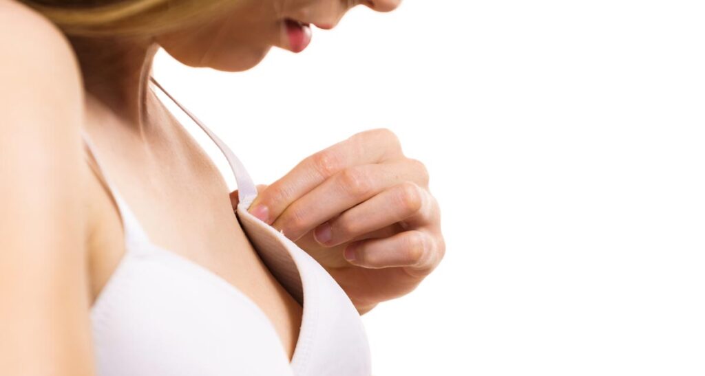 So finden sie den passenden BH für jedes Outfit. Ga-ran-tiert! 1 Die Hand einer Frau, die einen zu großen BH an ihre Brust drückt.
(c) AdobeStock