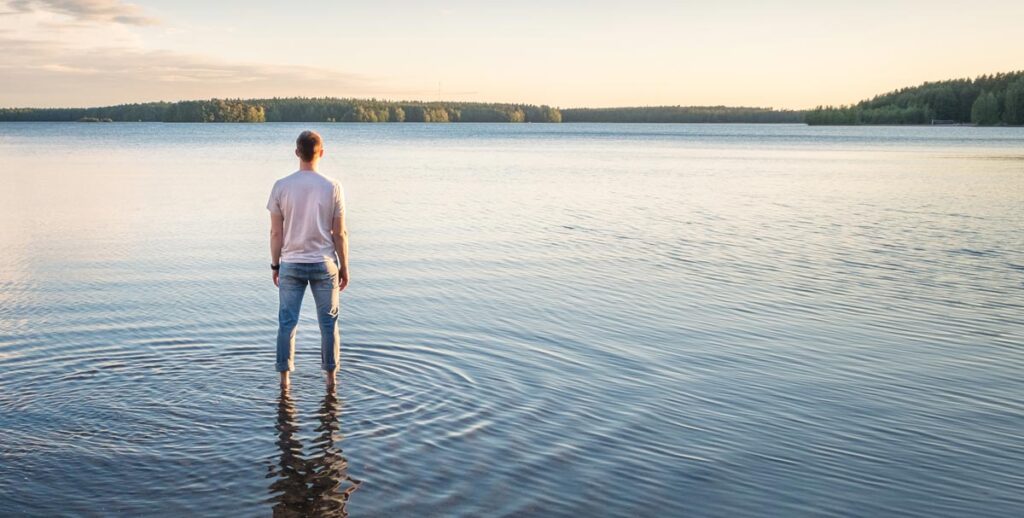 See zu warm – Land Burgenland meldet 500 Seebrunzer beim AMS 1 Ein Mann steht mit dem Beinen in einem See und schaut auf diesen hinaus, Stichwort Seebrunzer.
(c) AdobeStock