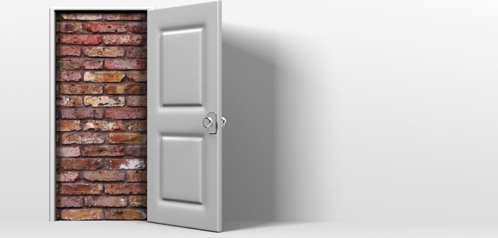 Eine offene Tür, die dahinter zugemauert ist. (c) AdobeStock