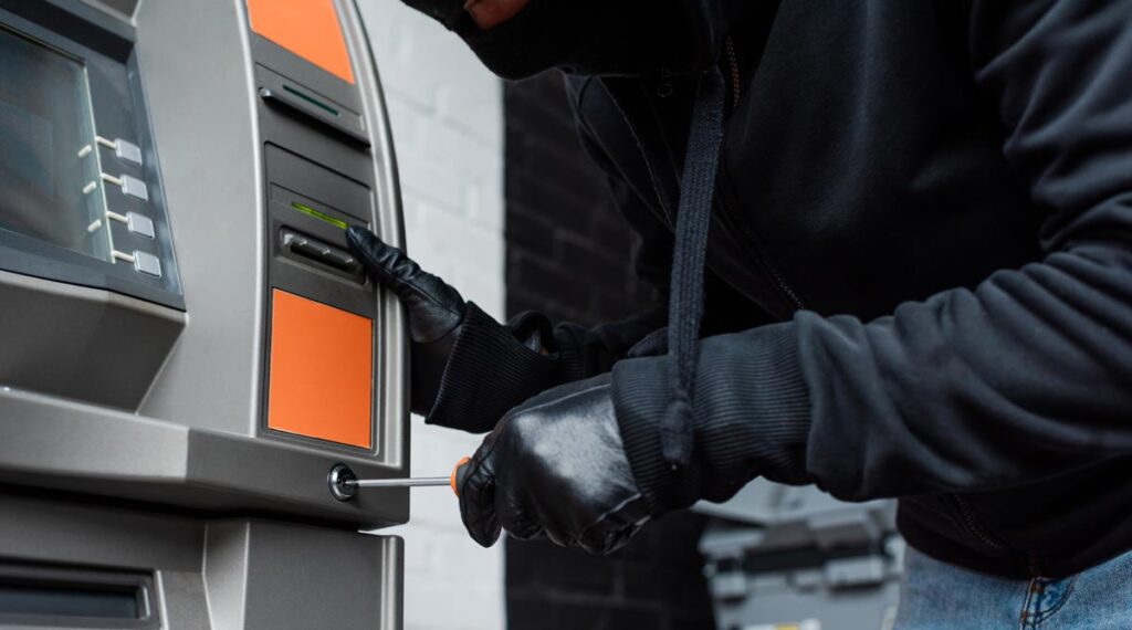 „Explosiv gebildet!“ – Bankräuber holen Sprengschein inkl. TÜV-Zertifikat in Abendkursen 1 Die Hand eines Bankräubers, der versucht, einen Bankomaten mit einem Schraubenzieher zu manipulieren.
(c) AdobeStock