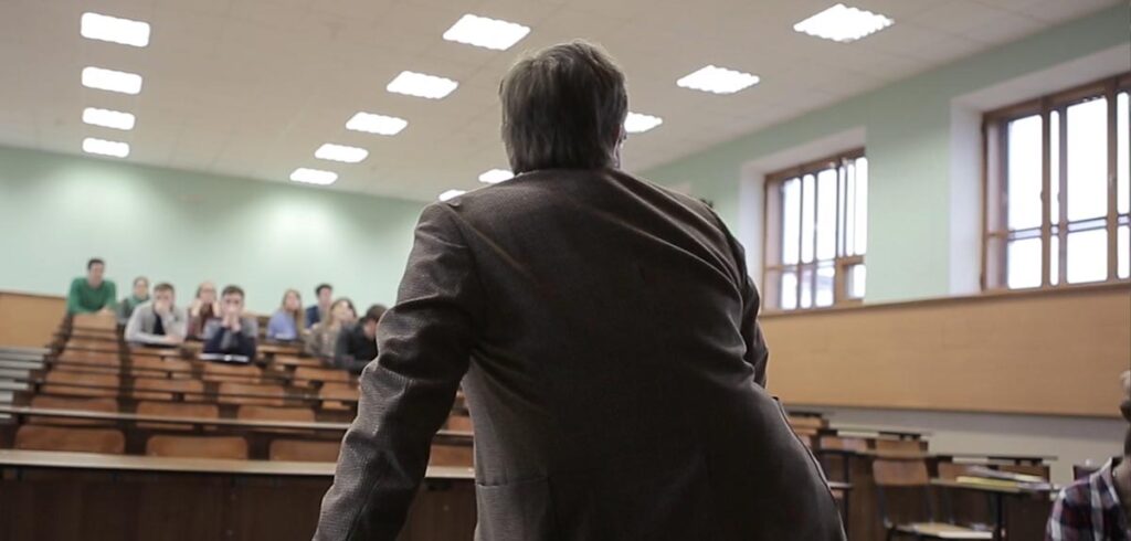 Ein Vortragender in einem relativ leeren Hörsaal. (c) AdobeStock