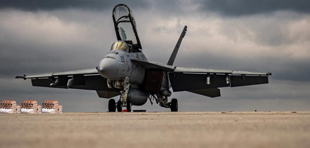 Ein F-16 Kampfflugzeug am Boden mit offener Pilotenkabine, daneben 3 Paletten Eier. (c) AdobeStock/ K2