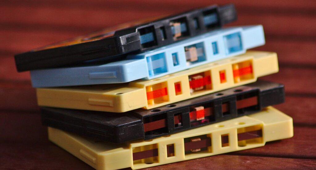 5 aufeinander gestapelte alte Audiokassetten, Stichwort WLAN-Kabel.
(c) AdobeStock