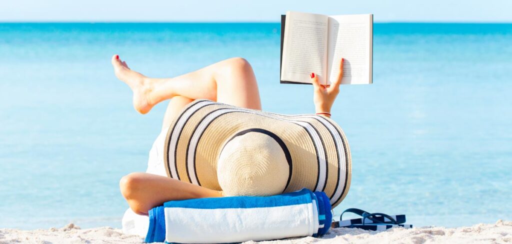 Diese 12 Fehler sollten sie beim Lesen am Strand »unbedingt« vermeiden. Plus: Buchtipps für den Sommer! 1 Eine Frau mit Sonnenhut liegt an einem Sandstrand und liest ein Buch.
(c) AdobeStock
