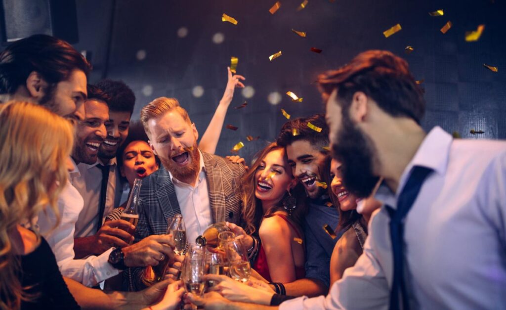Eine Gruppe junger Menschen beim Feiern einer Party, Stichwort Zoll.
(c) AdobeStock