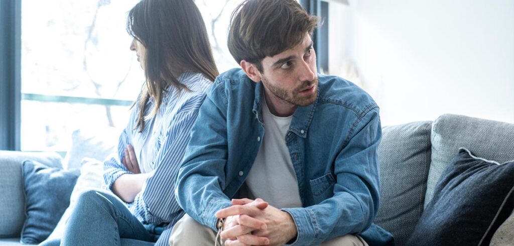 Ein Paar auf der Couch beim Streiten. (c) AdobeStock