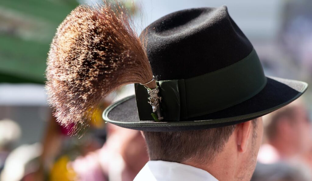 Der Kopf eines Mannes, der eine Trachtenhut mit großem Gamsbart auf hat, Stichwort Neustifter Kirtag.
(c) AdobeStock