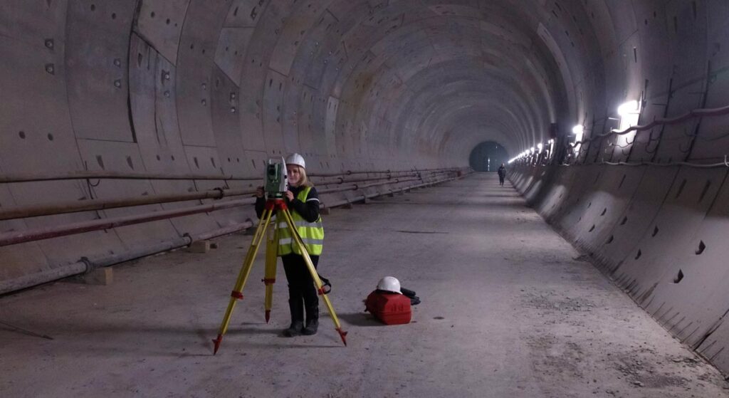 Eine Technikerin, die in einer Tunnelröhre Vermessungsarbeiten durchführt, Stichwort Lobautunnel.
(c) AdobeStock