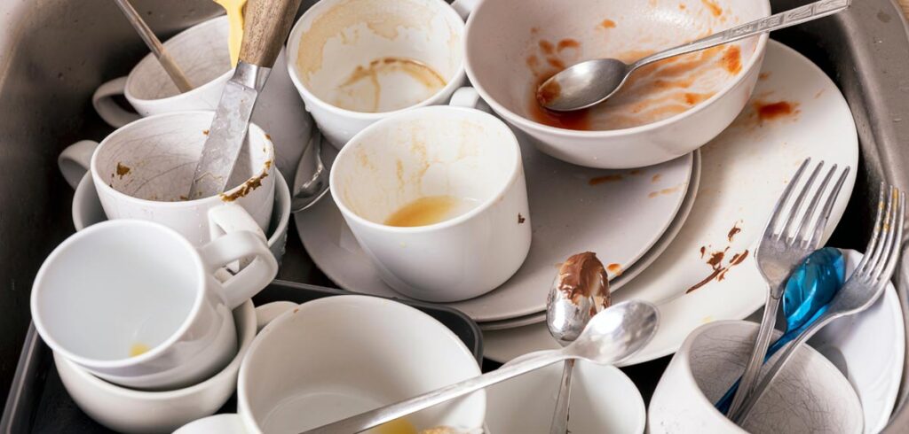 Schmutziges Geschirr in einer Spüle. (c) AdobeStock